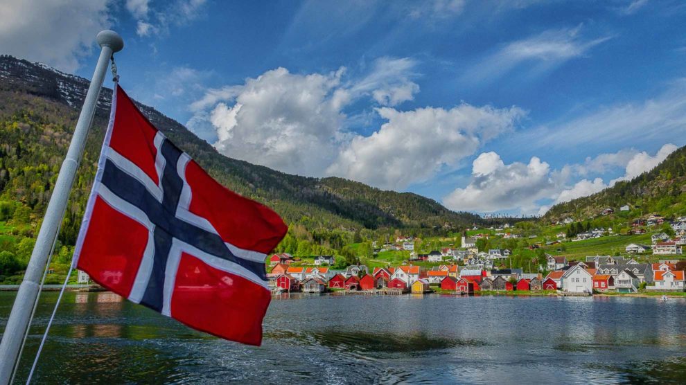 Titelbild-Faszination-Norwegen-Norwegische-Fahne-mit-Blick-auf-Solvorn-Norwegen-Nordlandblog-990x556-1