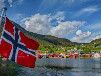 Titelbild-Faszination-Norwegen-Norwegische-Fahne-mit-Blick-auf-Solvorn-Norwegen-Nordlandblog-990x556-1